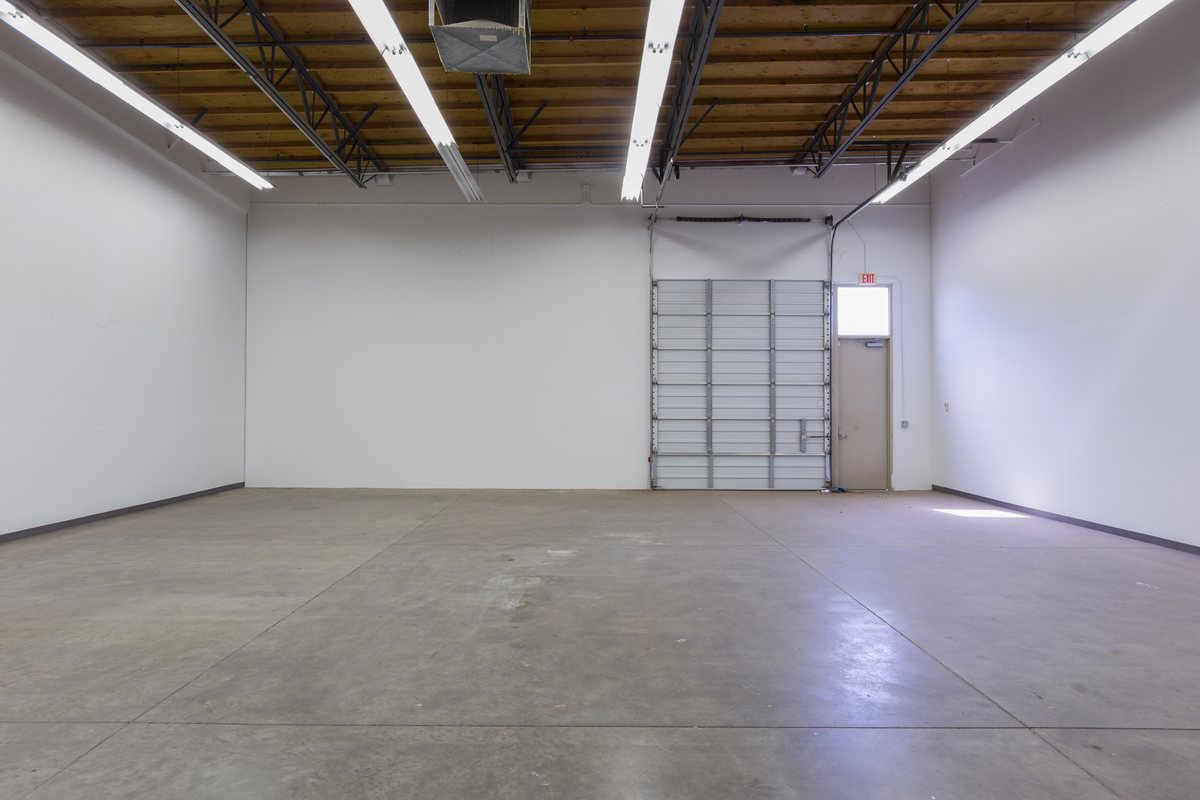 Clean small bay unit interior with high ceilings and polished slab